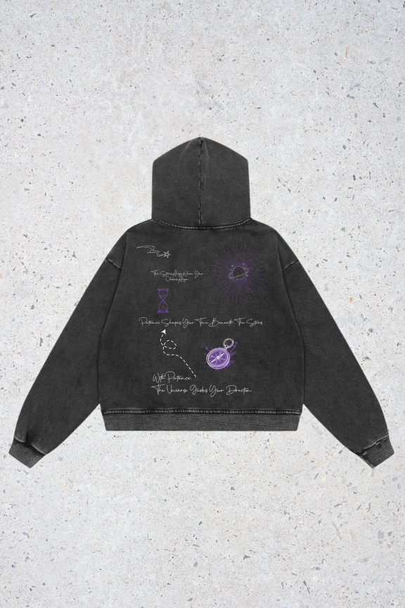 Black hoodie with purple graphics on a textured gray background