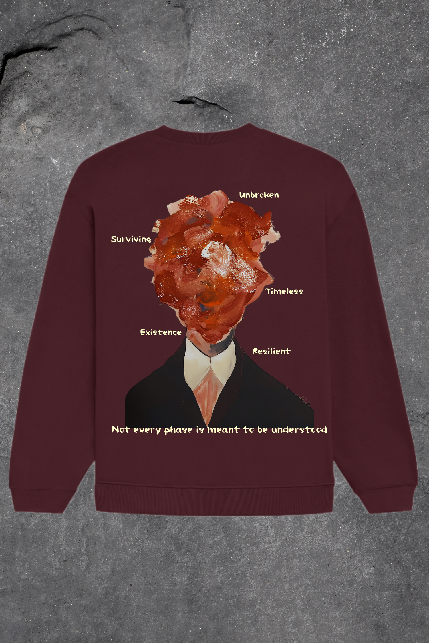 Maroon sweatshirt with graphic design and text on a textured gray background
