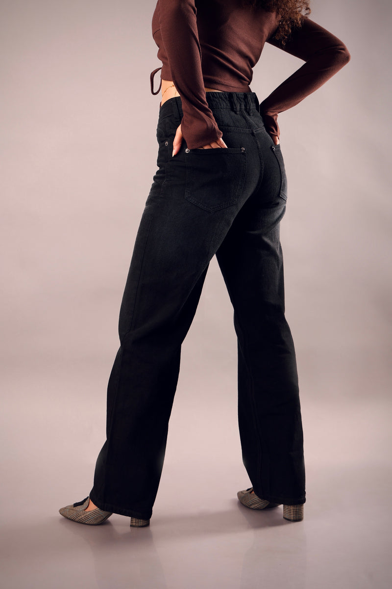 Back view of black straight fit jeans styled with oversized tee – Psypher