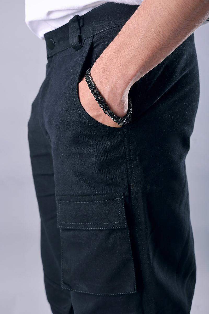 Close-up view of wide leg opening and cargo pockets – black streetwear pants